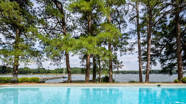 A swimming pool with a view of a lake and dock, surrounded by trees. - Minutes from Downtown St. Michaels | Pool | Cabana | Kayaks | Private Dock (St. Michaels)