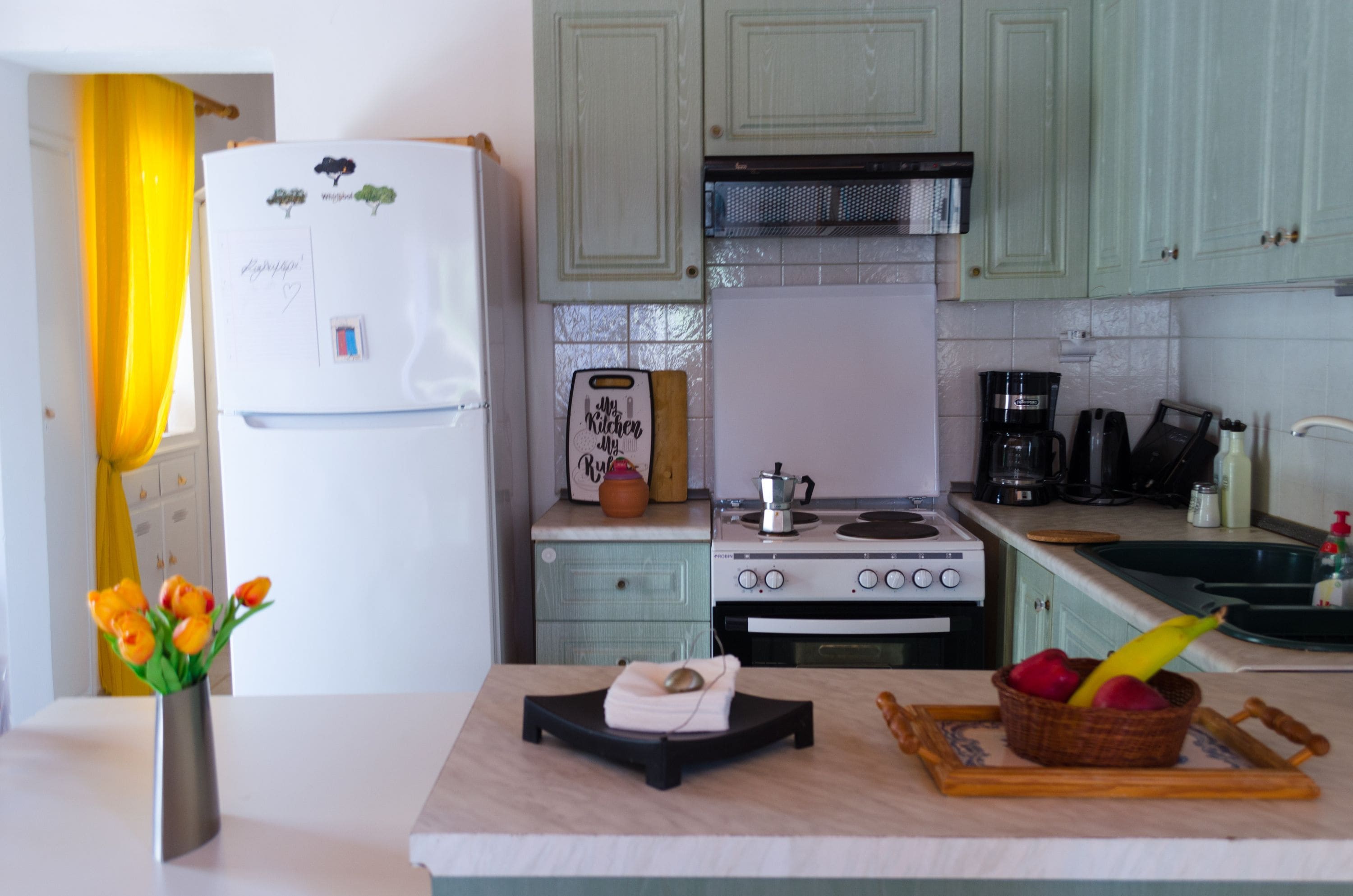 A kitchen with a refrigerator, stove, and various appliances.