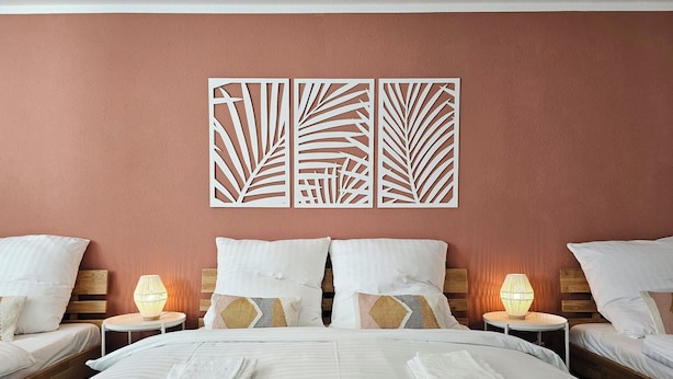 A hotel room with a large bed, two bedside tables with lamps, and decorative wall panels. - Kamingo for 12 people - Central, terrace, PS4 & Stream (Frankenberg (Eder))