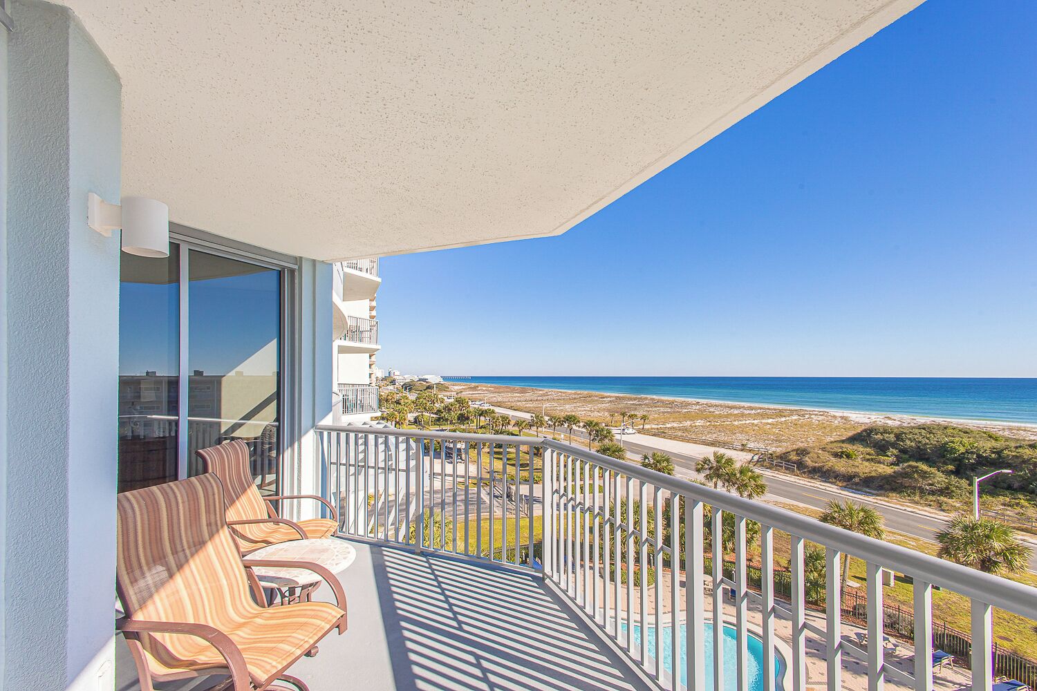 Ein Balkon mit Blick auf Strand und Pool.
