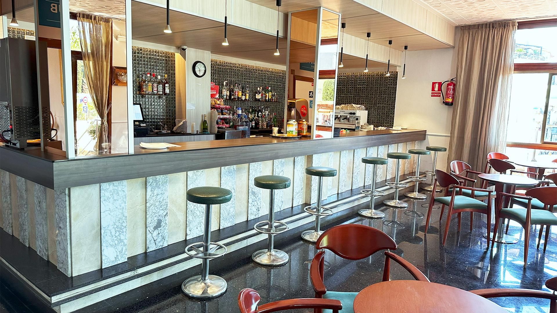 A bar area with a counter, stools, and seating.