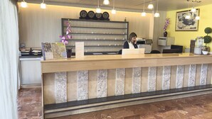 A reception desk with a marble counter, a clock above it, and a framed picture on the wall. - BLUESEA Continental (Tossa de Mar)