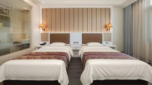 A hotel room with two beds, a large window, and a modern headboard.