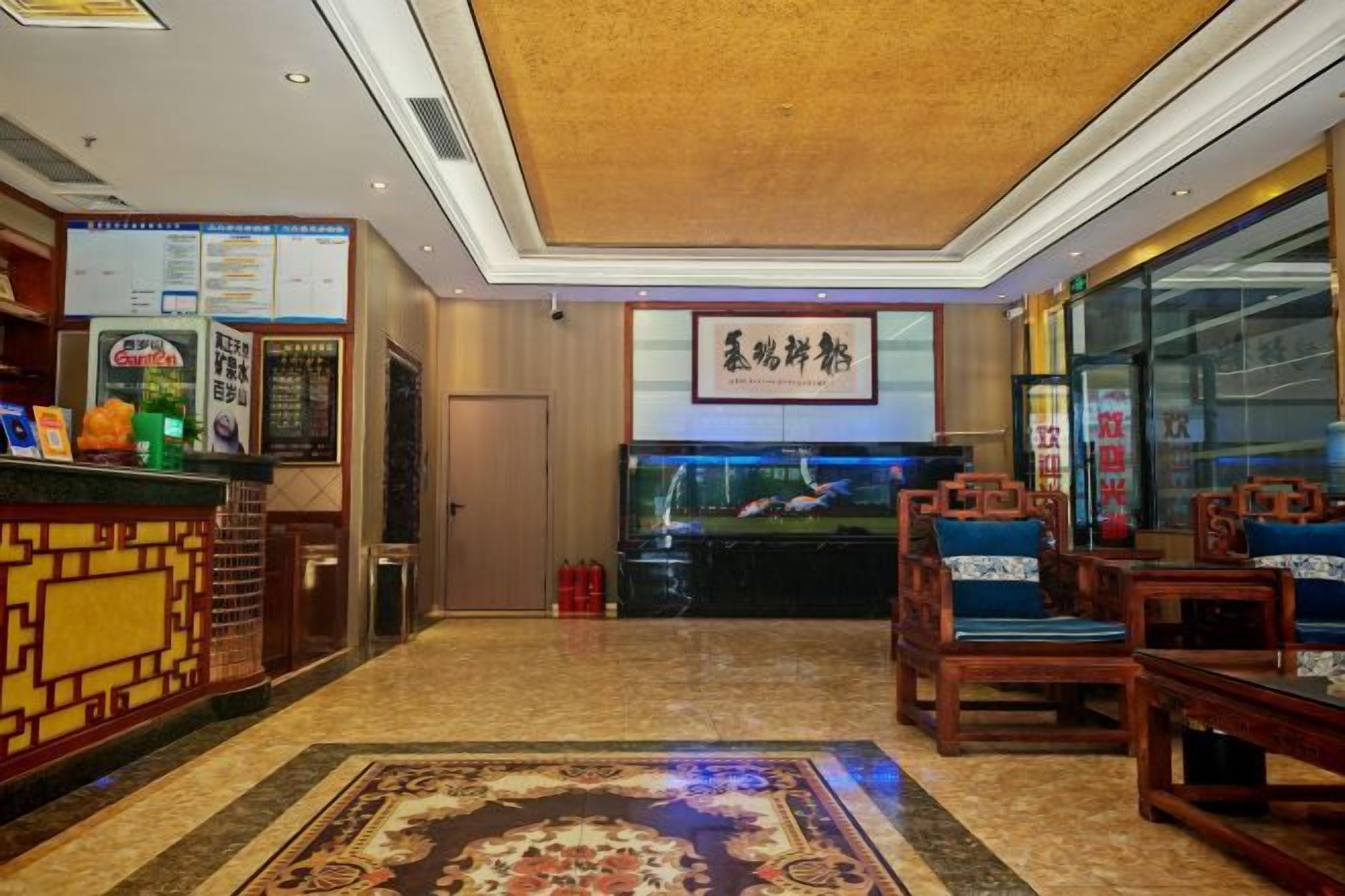 A hotel lobby with a reception desk, seating area, and a fish tank.