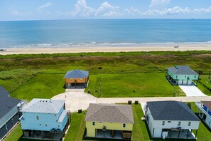 Zona residencial costera con casas, una playa y cielo despejado.