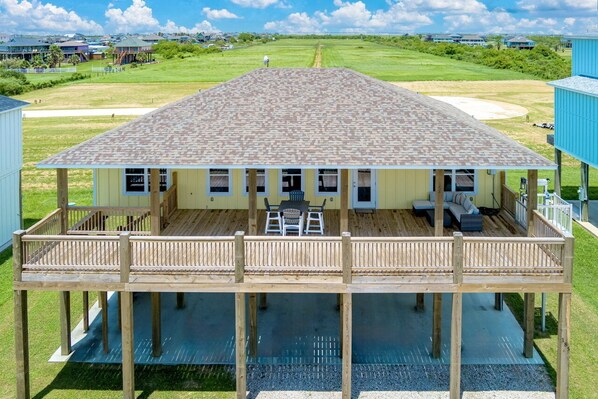 Una casa de dos pisos con balcón, un porche cubierto y vista a un campo de golf.