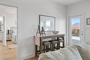 Un dormitorio con una cama, una mesita de noche con lámpara y una ventana.