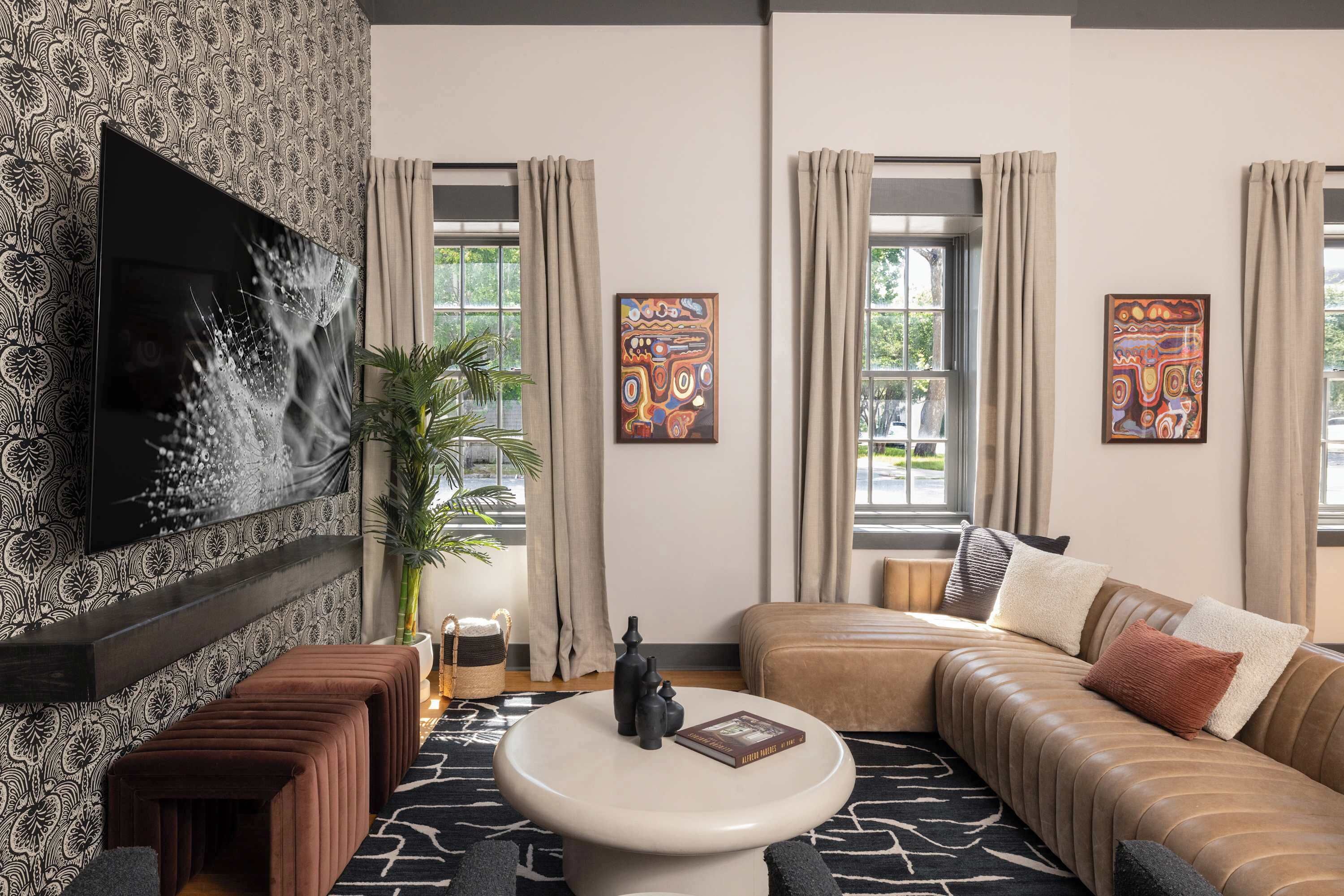 A modern living room with a sofa, a coffee table, and a flat-screen TV mounted on the wall.