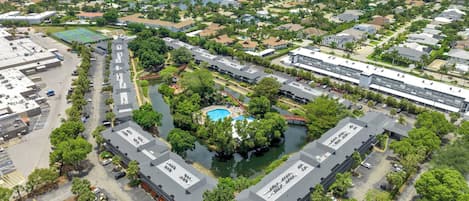 A residential area with a large building complex, a swimming pool, and a marina.