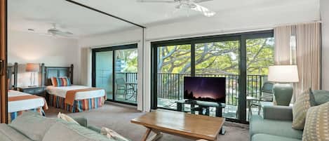 A spacious living area with a sofa, a coffee table, and a TV on a balcony.