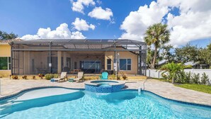 A swimming pool with a hot tub, lounge chairs, and a covered patio area. - Peace River Waterfront Luxury Living - 5-BD w Pool (Port Charlotte)