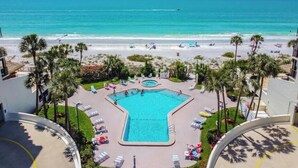 A resort with a central swimming pool, palm trees, and a beach view. - Ocean Sands 1-1002☀️Beachfront,Private Balcony,Walk 2 Restaurants🏖️Beach Access (Madeira Beach)