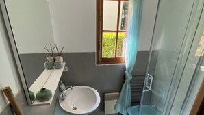 Un baño con bañera, lavamanos, inodoro y ducha con mampara de vidrio.