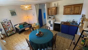 Un espacio habitable pequeño con comedor, kitchenette y sofá.