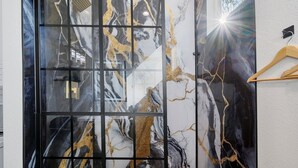 A room with a large abstract painting on the wall, a wooden floor, and a wooden hanger on the wall.