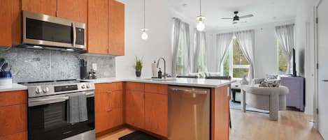 Una cocina moderna con armarios de madera, electrodomésticos de acero inoxidable y una isla central.