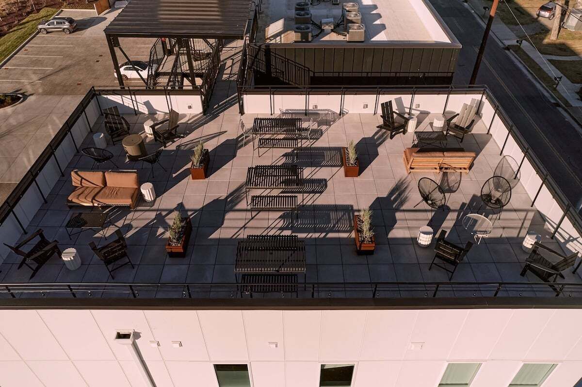 Une terrasse sur le toit avec des sièges extérieurs, un espace abrité et une vue sur la rue.