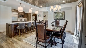Una cocina amplia con gabinetes de madera, una isla central y taburetes de bar.