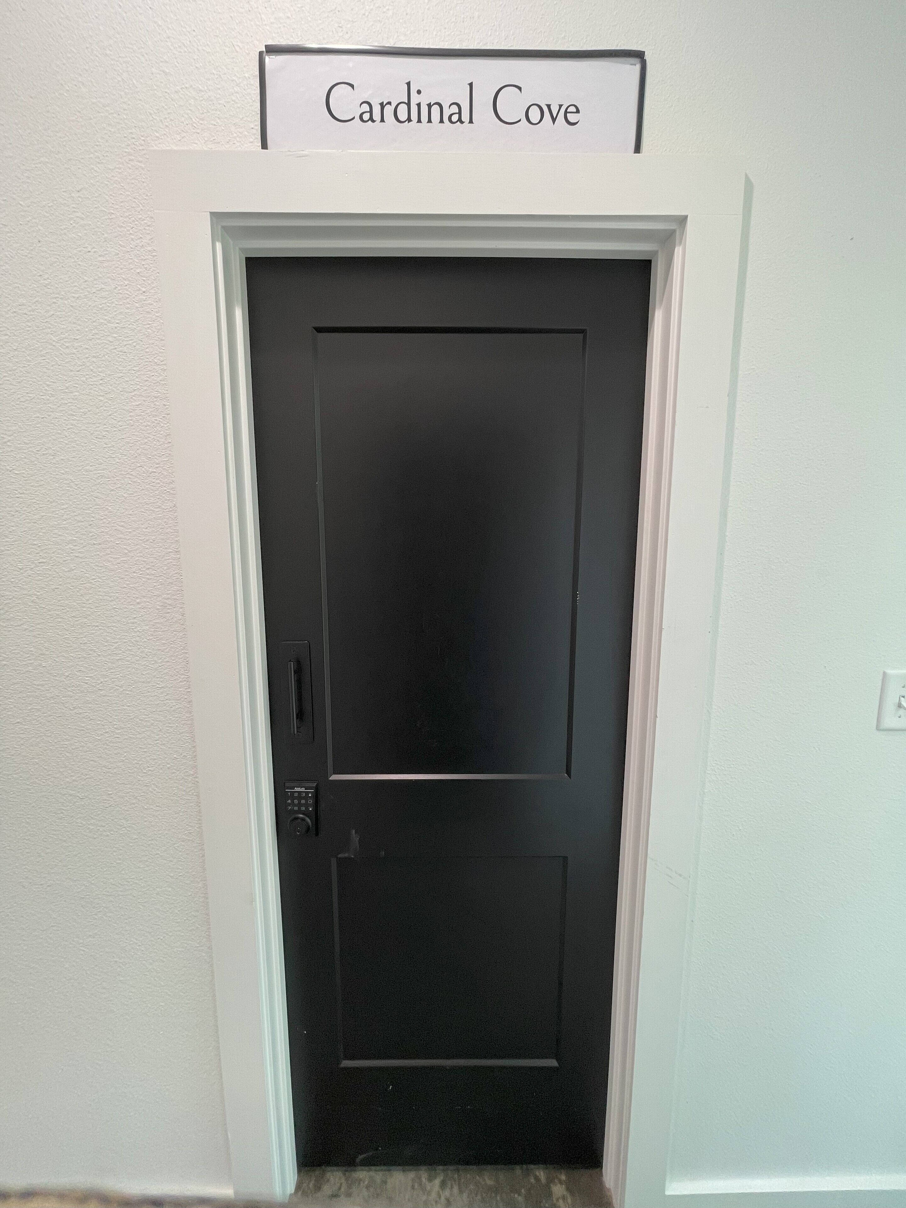 Eine schwarze Tür mit einem Schild darüber, auf dem 