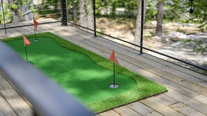 A wooden deck with artificial green turf and two orange flags.