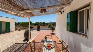 A covered patio area with a table set for two, featuring a pitcher and glasses. - 4072 Trull' Itria by Barbarhouse (Martina Franca)