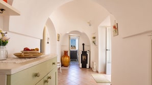 A kitchen with a large vase, a bowl of fruit, and a stove. - 4072 Trull' Itria by Barbarhouse (Martina Franca)