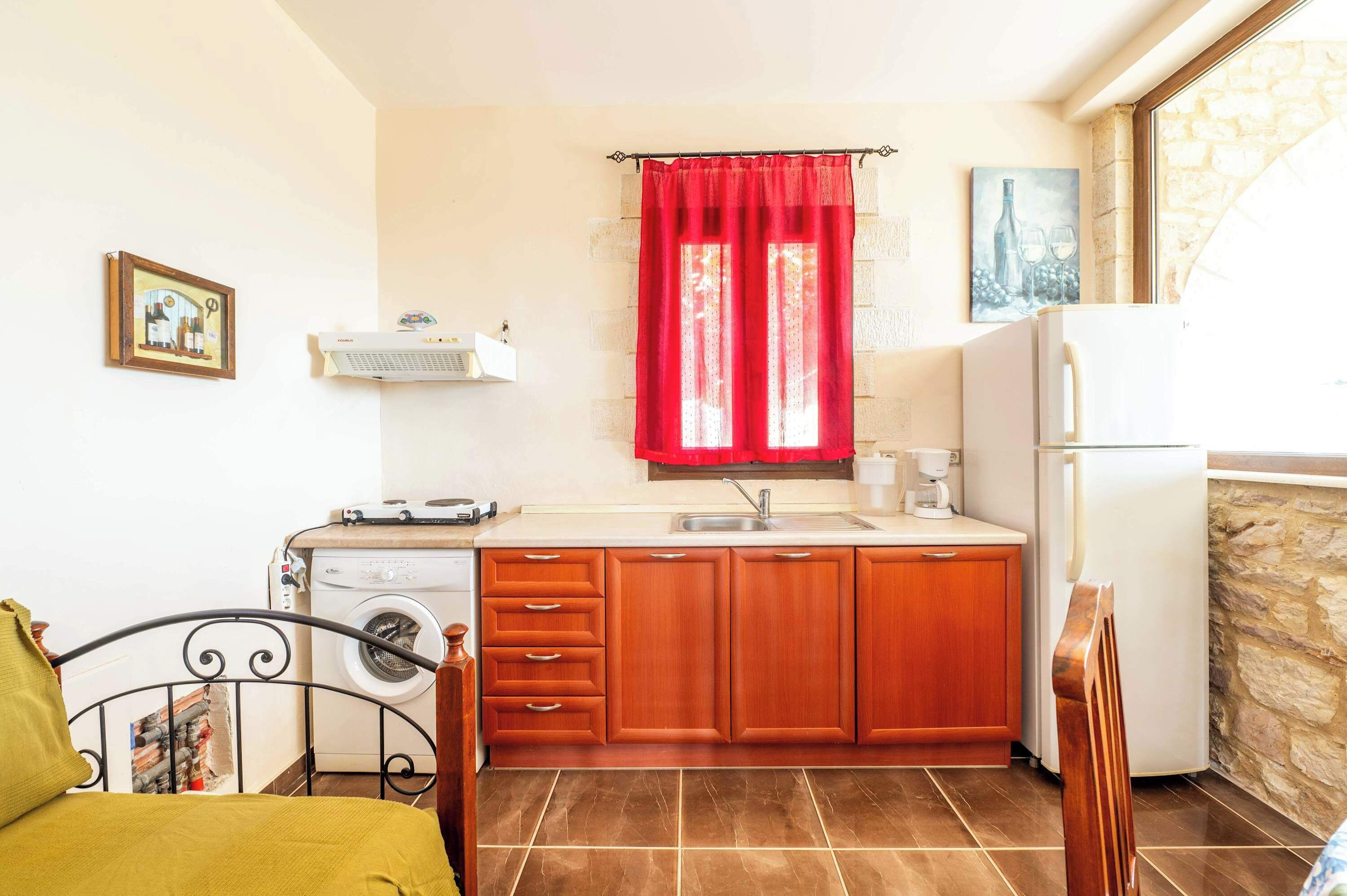 Cocina compacta con lavadora, lavaplatos y refrigerador.