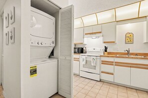 A modern kitchen with a built-in washer and dryer, a microwave, a stove, and a sink. - 2 Bed 2 Bath Condo on Golf Course in Quiet Safe Community, 4 Miles to Beach (Venice)