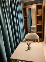 Una habitación con una mesa, una silla y un armario con espejo.