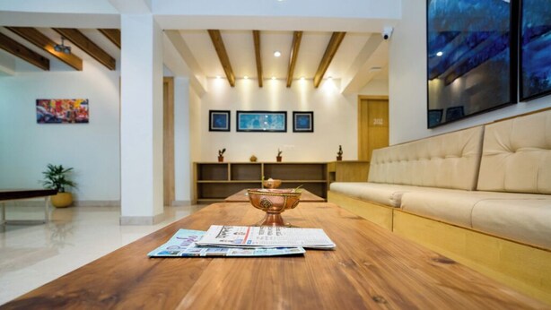 A modern living room with a wooden coffee table, a beige sofa, and a decorative bowl. - Hotel Finger lime (Gangtok)
