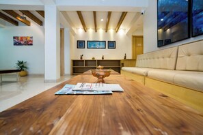 A modern living room with a wooden coffee table, a beige sofa, and a decorative bowl. - Hotel Finger lime (Gangtok)