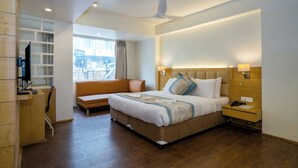 A modern hotel room with a large bed, a desk, a chair, and a TV. - Hotel Finger lime (Gangtok)
