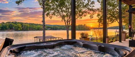 Un jacuzzi con vistas a un lago y al atardecer.