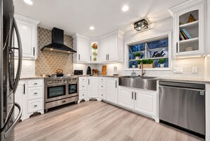 Cook, gather, and settle in with a bright, fully equipped kitchen featuring stainless steel appliances, generous counter space, and a farmhouse sink.