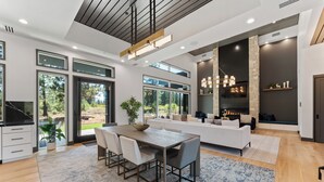 Una cocina moderna con comedor, ventanas amplias y chimenea de piedra.