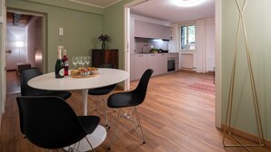 A dining area with a round table, black chairs, and a bottle of champagne. - San Beneto  (Venice)