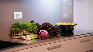 A kitchen counter with fresh vegetables, a pot of pasta, and a power outlet. - San Beneto  (Venice)
