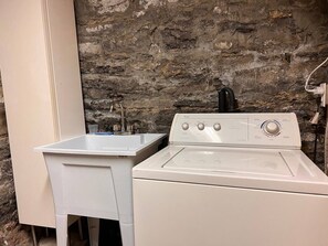 A laundry area with a washing machine and a sink. - Charming sunny vintage studio with a balcony in the heart of Plateau Mont-Royal. (Montréal)
