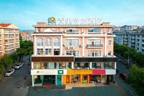 A multi-story hotel with a central atrium, multiple balconies, and a ground-level retail space. - QIngGuo intelligence Hotel (Jiashan)