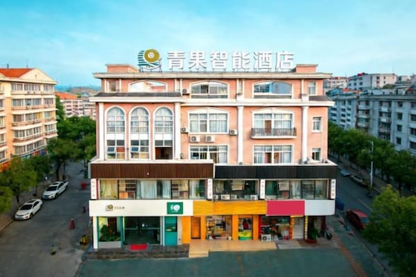 A multi-story hotel with a central atrium, multiple balconies, and a ground-level retail space. - QIngGuo intelligence Hotel (Jiashan)