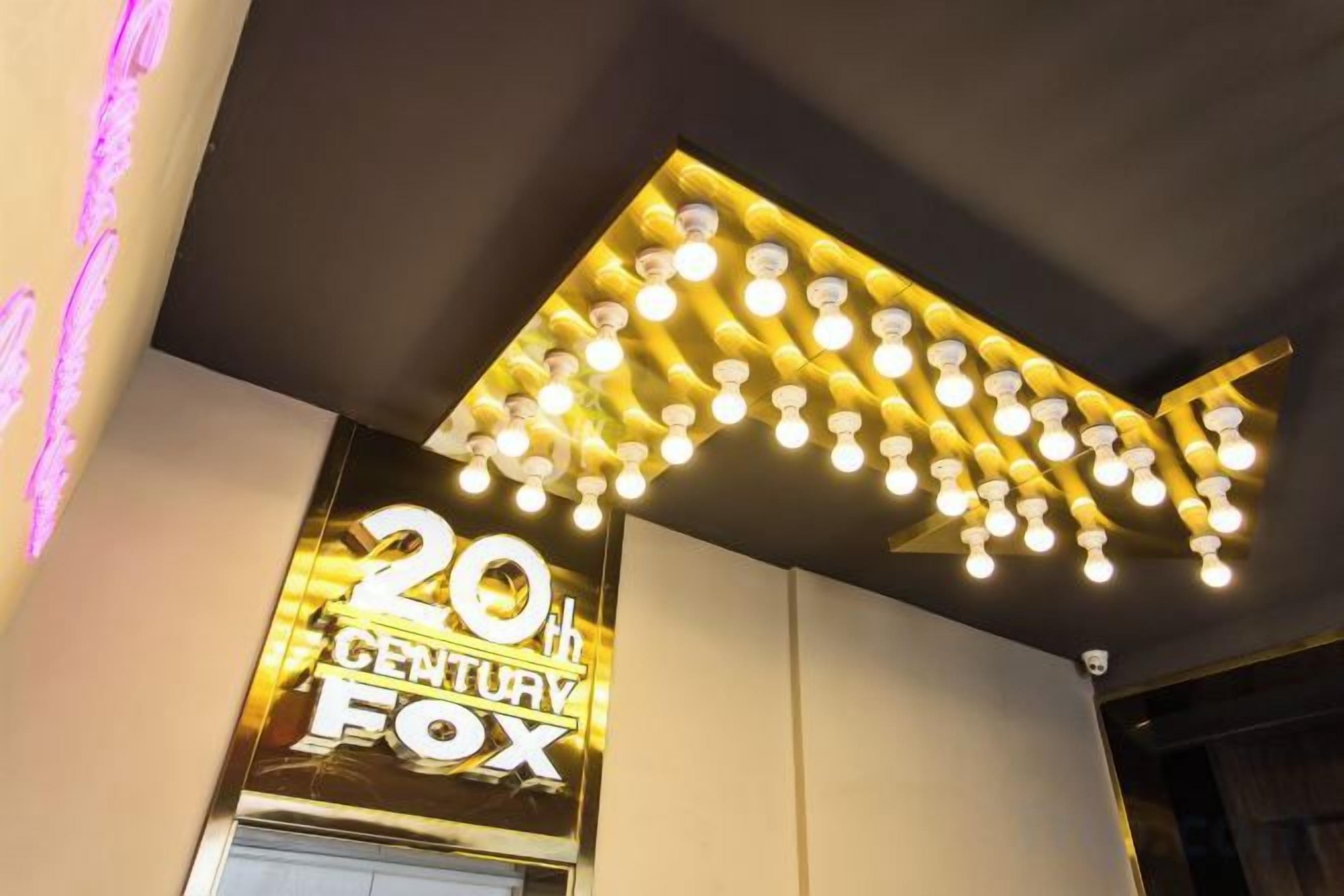 Un panneau de 20th Century Fox surmonté d’un luminaire moderne.