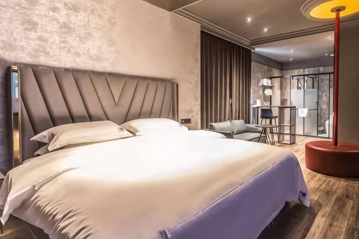 Una camera d'albergo moderna con un letto grande, una scrivania e una sedia.