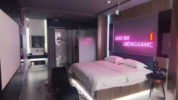 Un dormitorio moderno con una cama, un letrero de neón, una mesita pequeña y una silla.