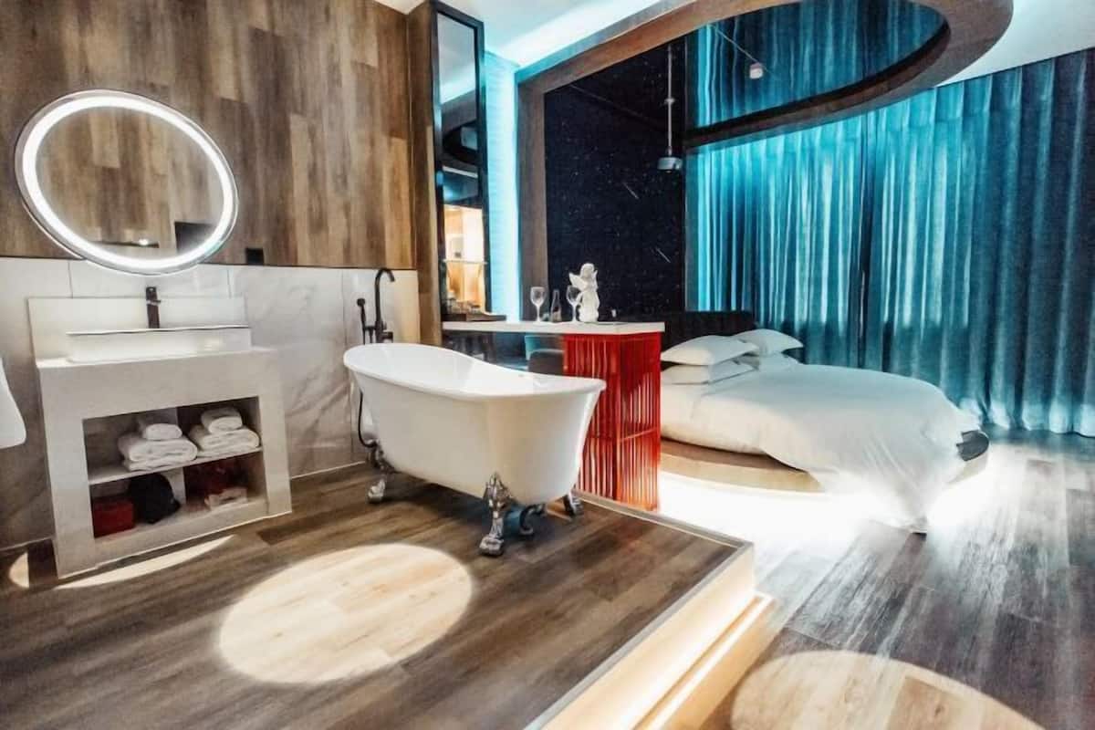 Un bagno moderno con una vasca da bagno indipendente, un mobile lavabo con specchio e uno scaffale contenitore con asciugamani.
