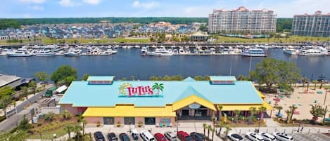 A marina with boats, a parking lot, and a building with a 'Lulu's' sign.