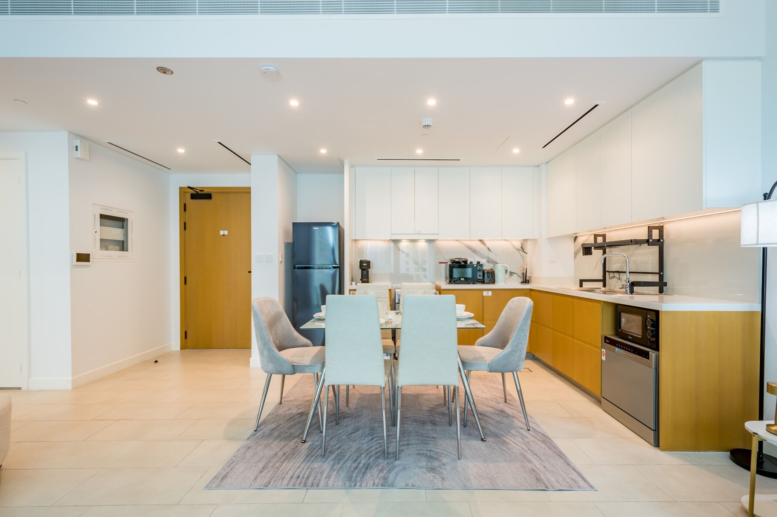 A modern kitchen with white cabinets, a built-in oven, and a dishwasher.