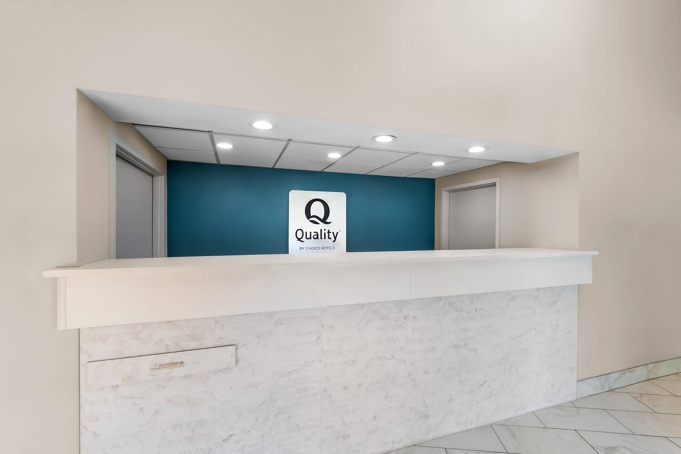 A reception desk with a sign that reads 'Quality by Choice Hotels.'