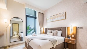 A modern hotel bedroom with a large bed, bedside tables, a mirror, and a view of the city. - Inviting 2BR Apartment in Azizi Riviera 39, Al Merkadh by Deluxe Holiday Homes (Dubai)