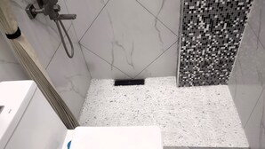 A bathroom with a white sink, a shower with a tiled wall, and a marble floor. - New Furn 1 Br/1 Bath/Kitchen, Manila-Univ Belt, AC, Hot water, Wifi, Netflix -u1 (Manila)