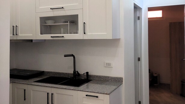 A modern kitchen with white cabinets, a built-in microwave, and a black faucet. - New Furn 1 Br/1 Bath/Kitchen, Manila-Univ Belt, AC, Hot water, Wifi, Netflix -u1 (Manila)